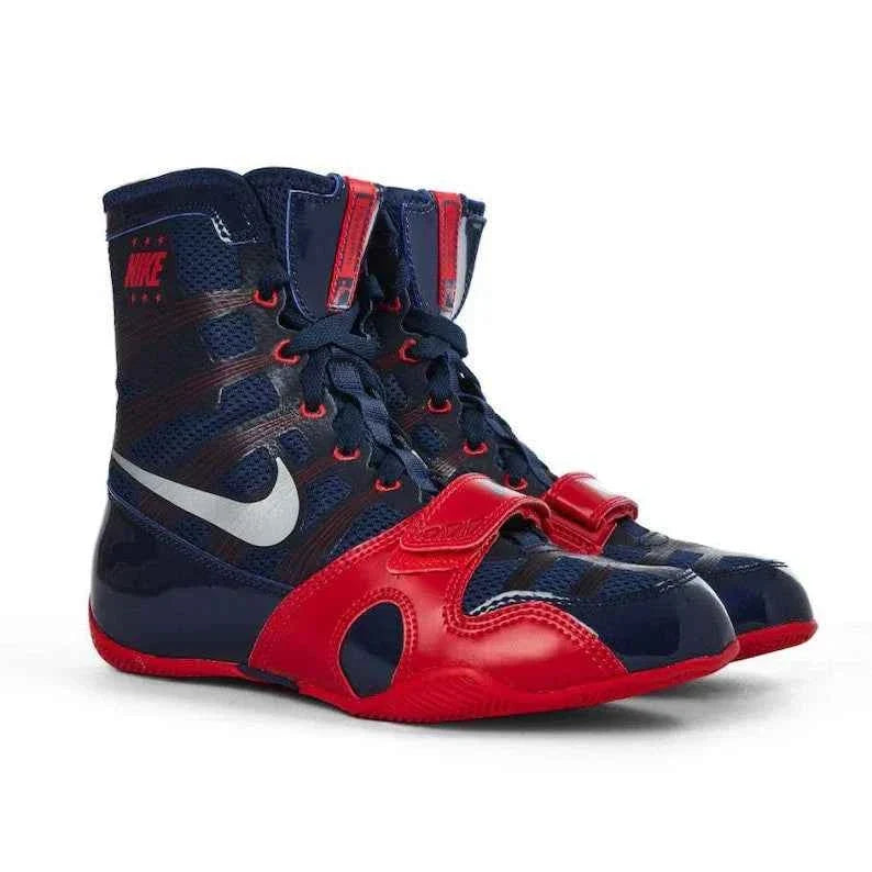 A pair of Custom Nike HyperKO boxing shoes in a navy blue and red colorway, featuring a red forefoot lockdown strap and a white Nike Swoosh, displayed on a white background.