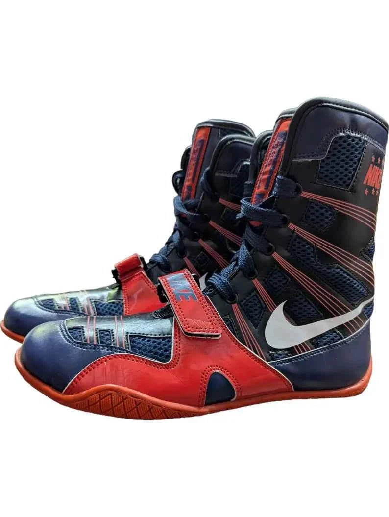 A pair of Custom Nike HyperKO boxing shoes in a navy blue and red colorway, featuring a red forefoot lockdown strap and a white Nike Swoosh, displayed on a white background.