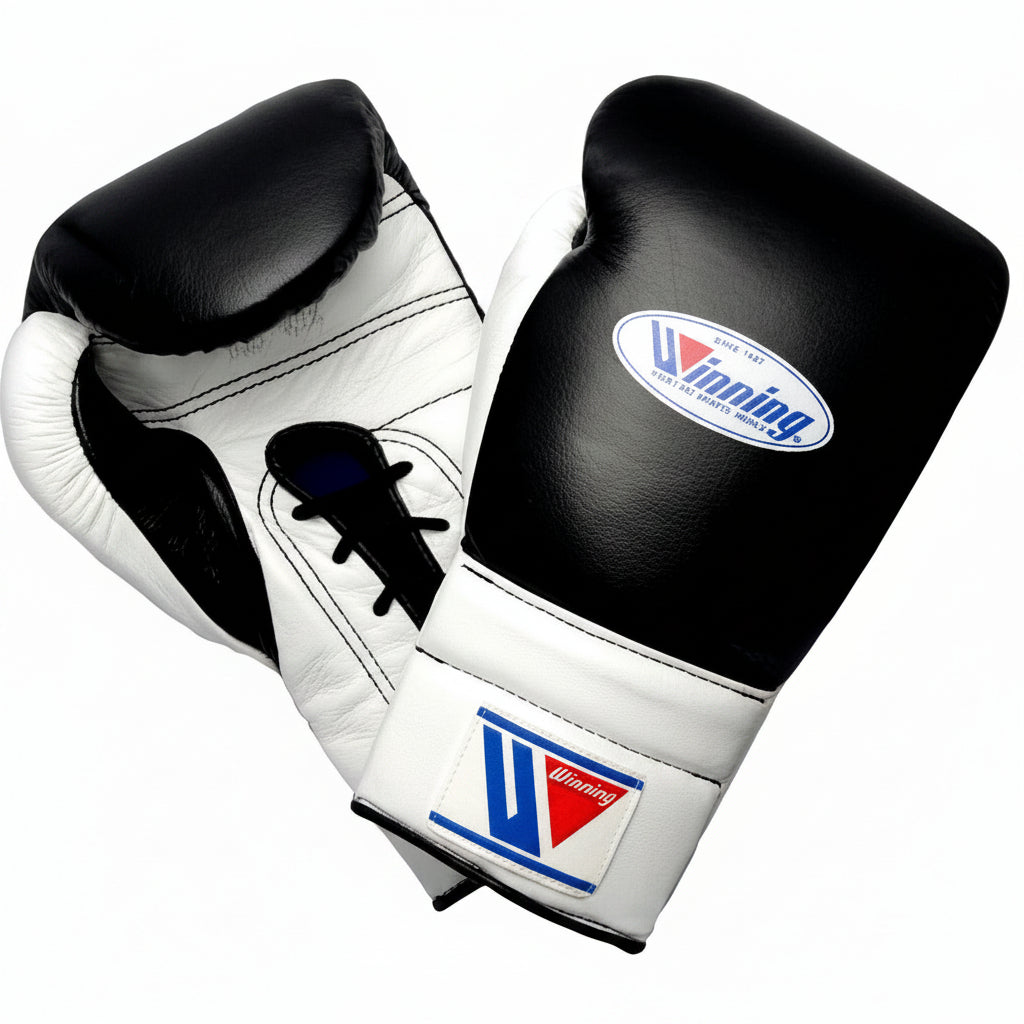 A pair of black and white boxing gloves with the Winning brand logo visible on the wrist strap and front glove.